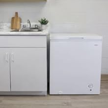 Koolatron white chest freezer, closed, set up beside a white kitchen counter and sink